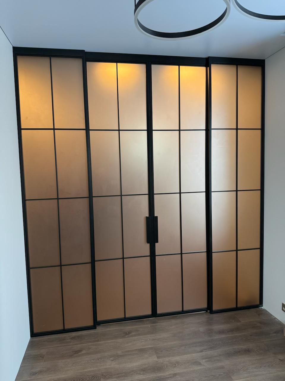 Doble puerta corrediza que se oculta detrás de paneles fijos en cocina